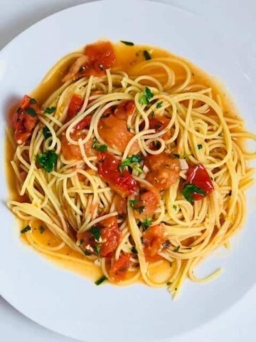 pasta with sauce and tomatoes on a white plate