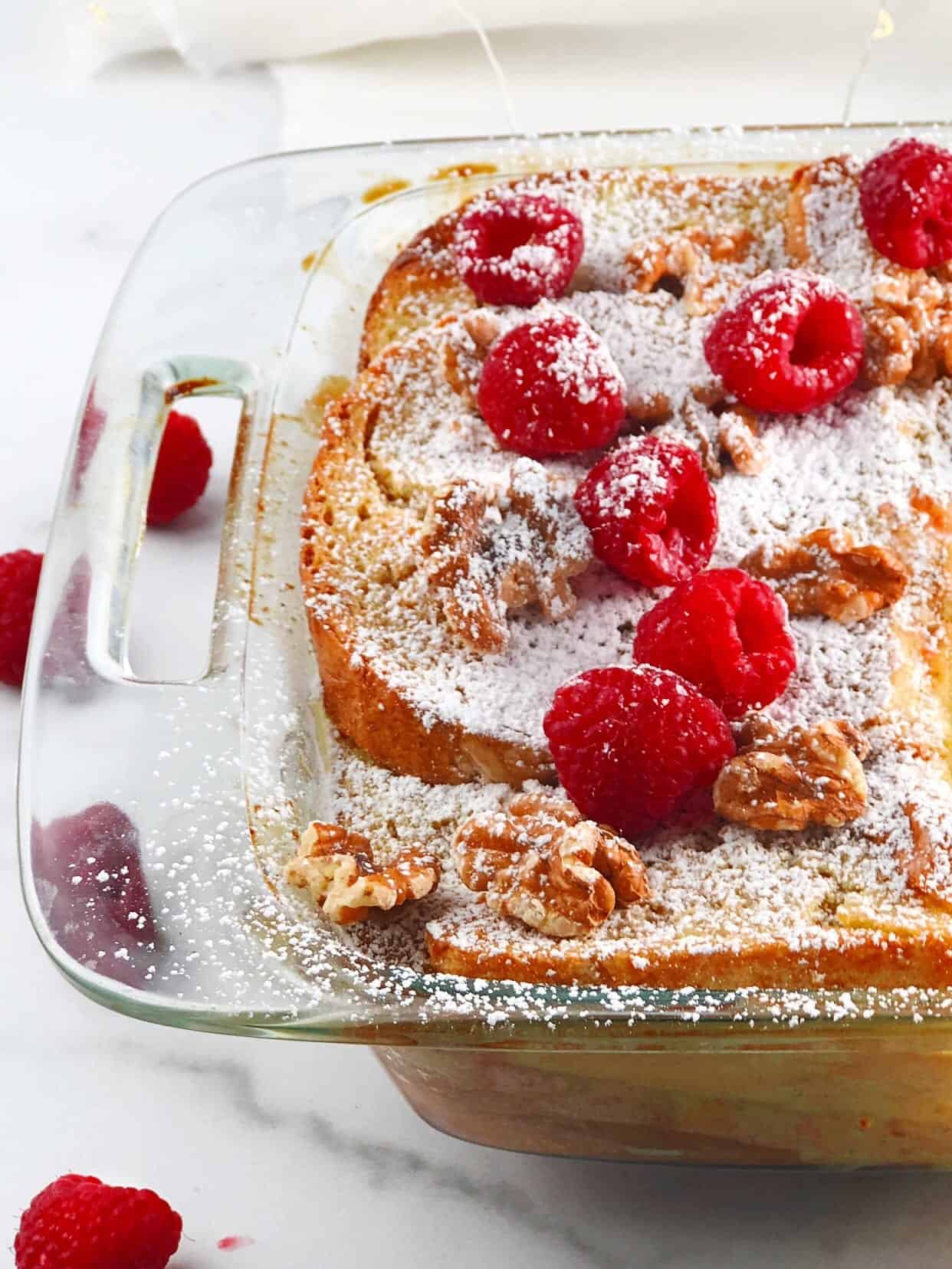 Baked French toast in a pan with berries on top.