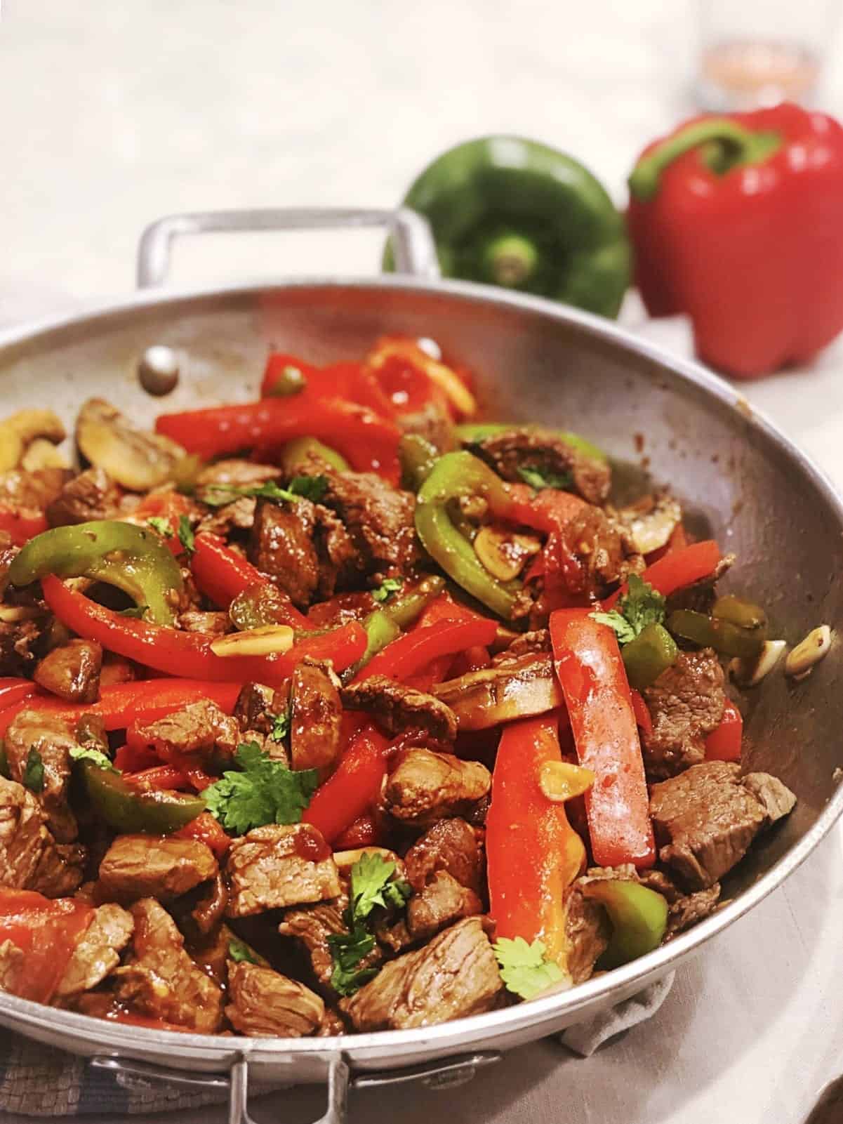 A skillet full of meat and peppers, perfect for making Pepper Steak.