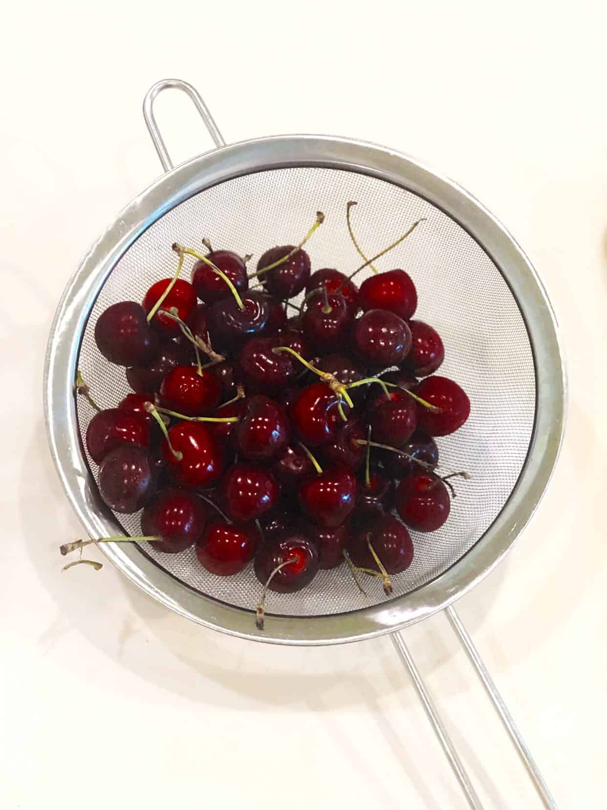 fresh cherries in strainer