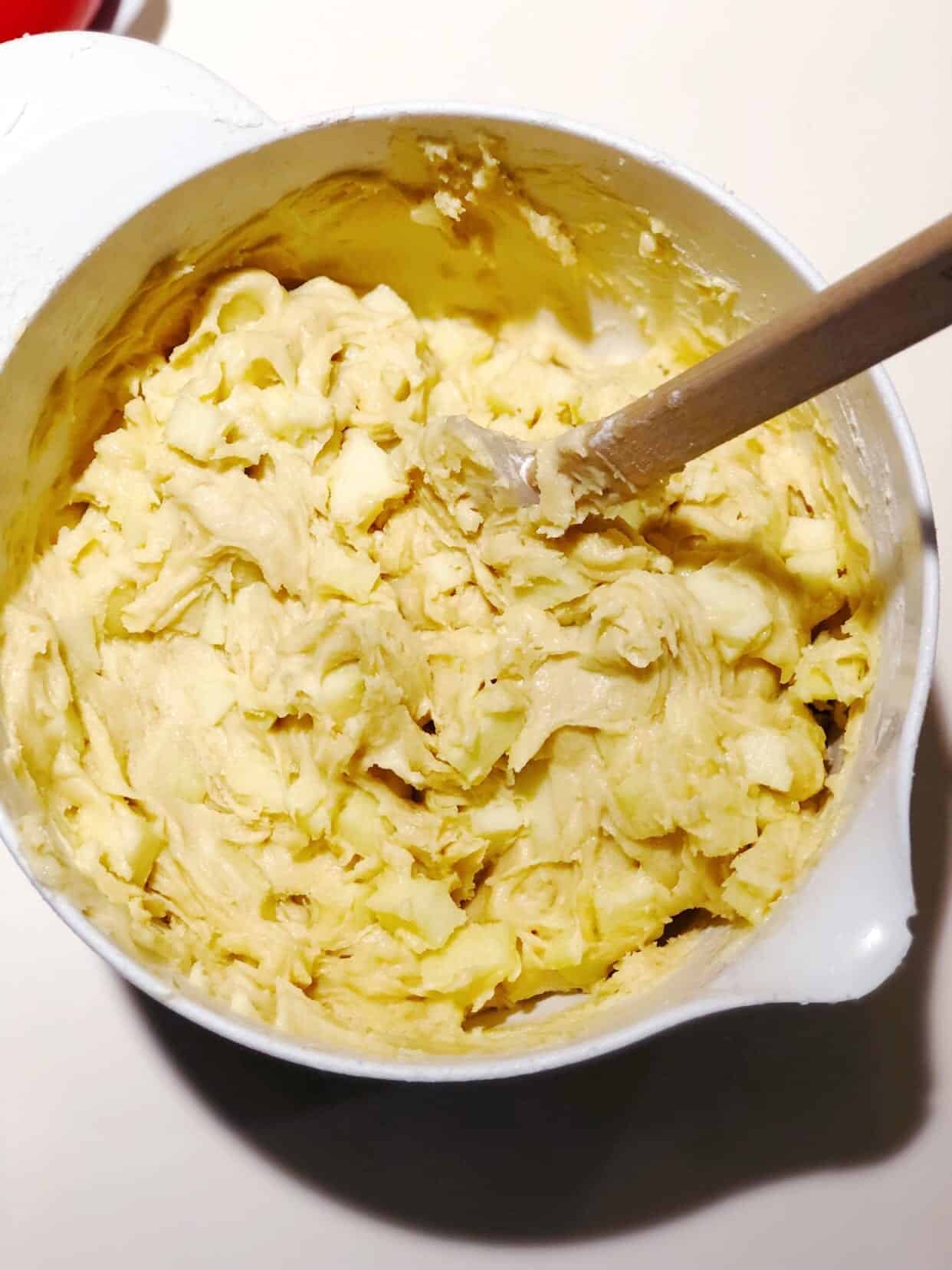 adding apples to the cake batter