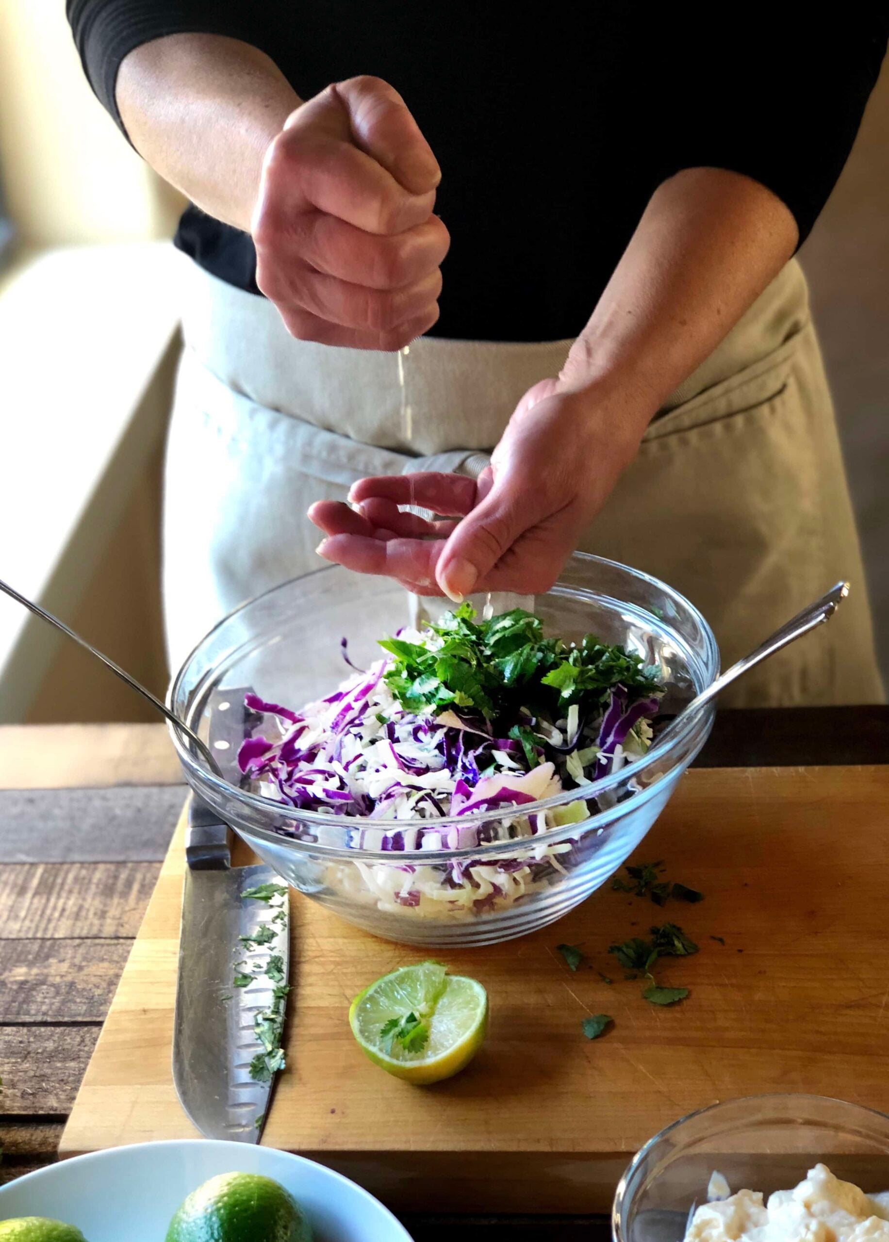 Cumin and lime coleslaw are being made on the table.