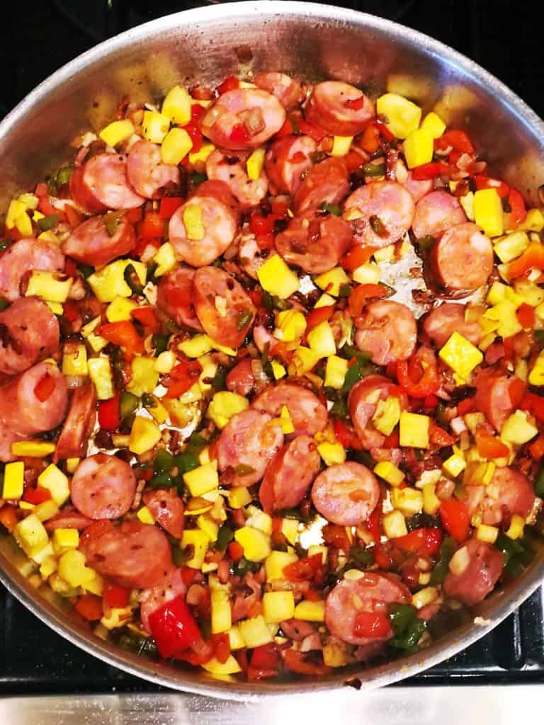 adding sausage to jambalaya