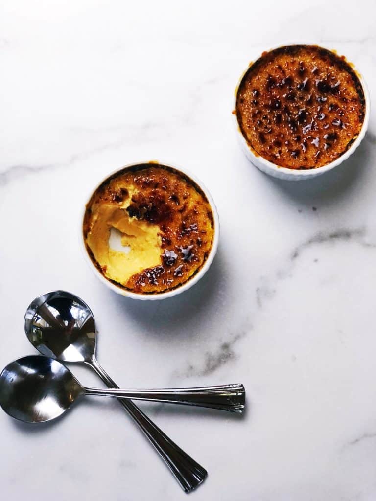 pumpkin custards in ramekin with a bite taken out of one of them