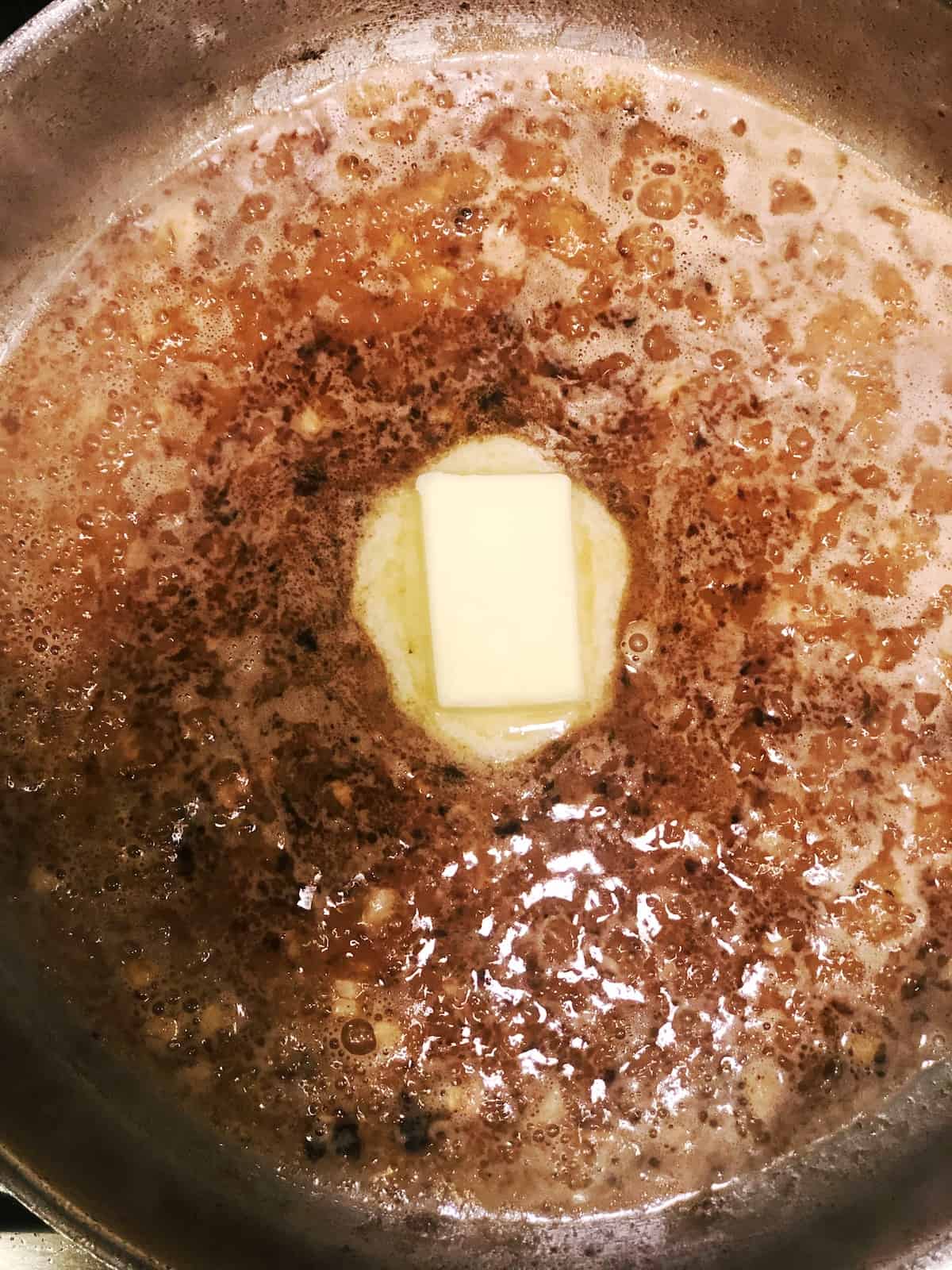 adding butter to pan for lemon chicken sauce