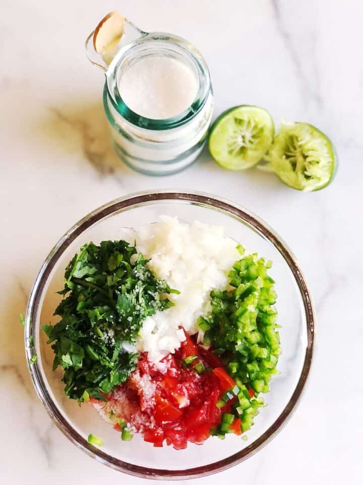 adding salt and lime to pico de gallo