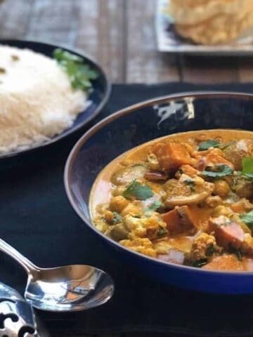 Indian vegetable curry with coconut milk in bowls on table