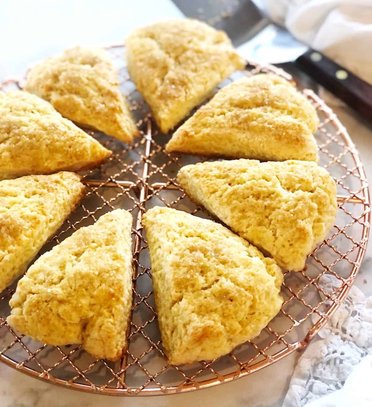 scones on a cooling rack with a knife.