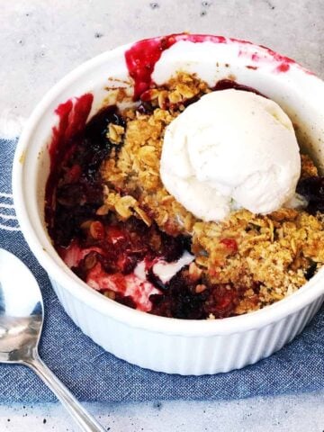 berry-crisp in bowl with ice cream on top
