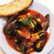 Spanish mussels in bowl with crusty bread on side