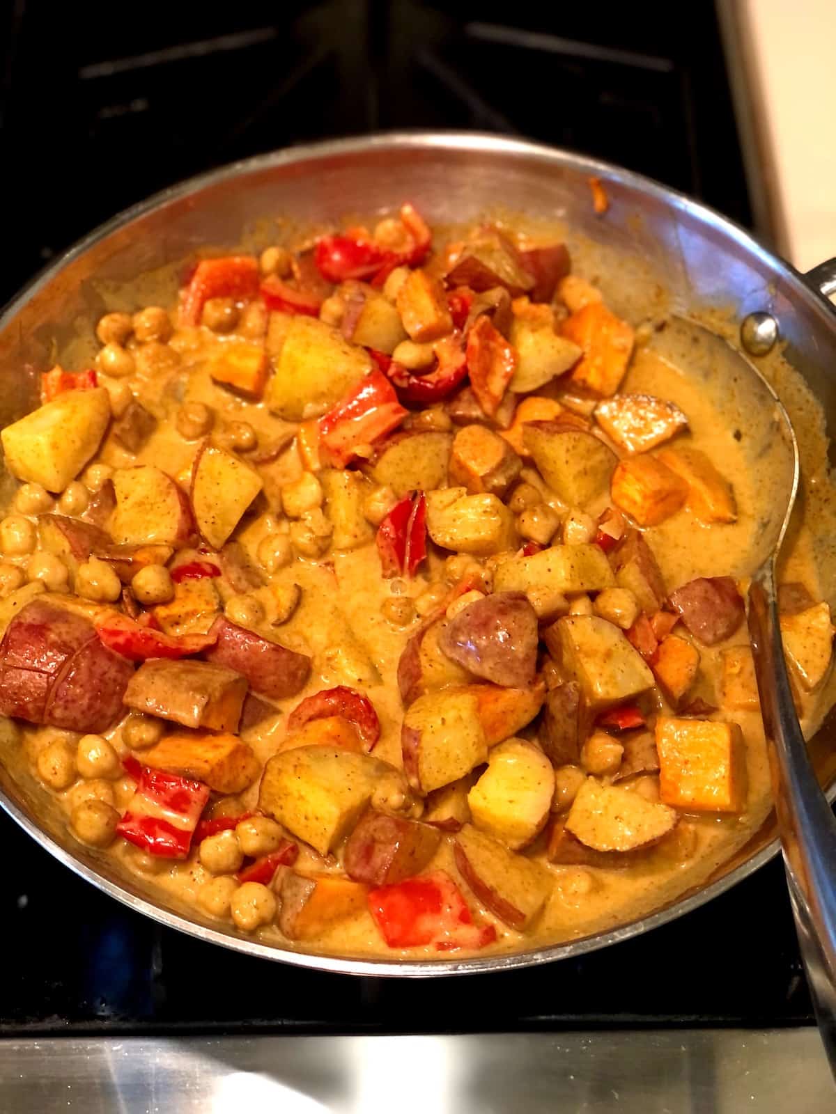 simmering vegetable curry in pan on stove