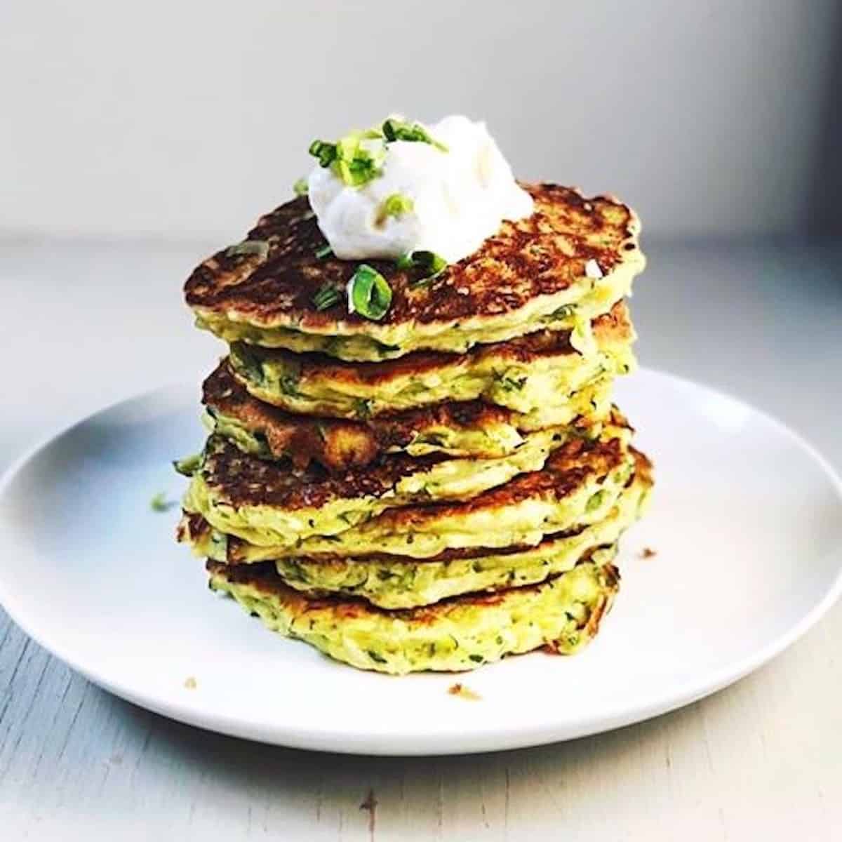 zucchini pancakes stacked up on plate