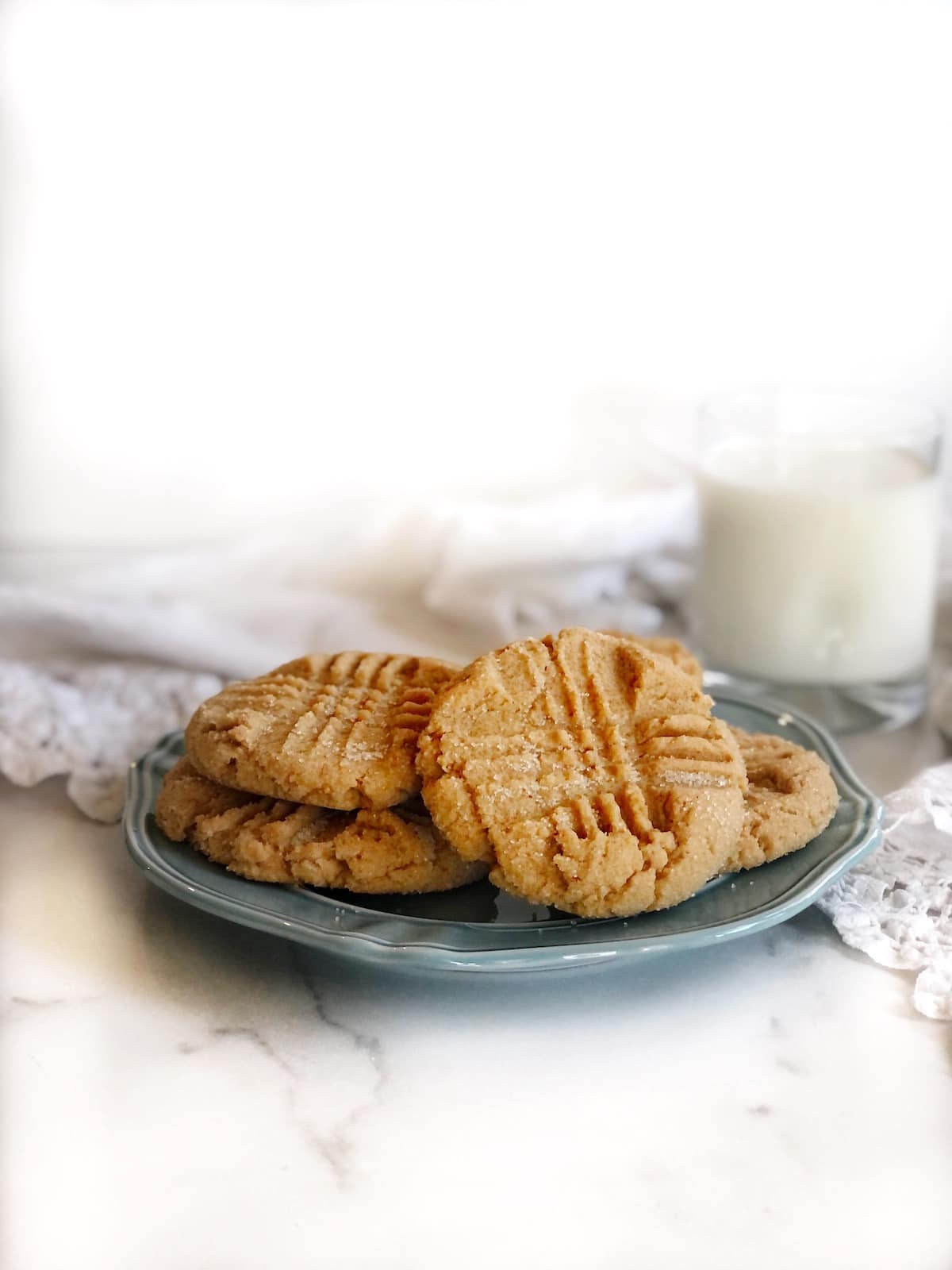 chewy peanut butter cookies stacked up on a plate