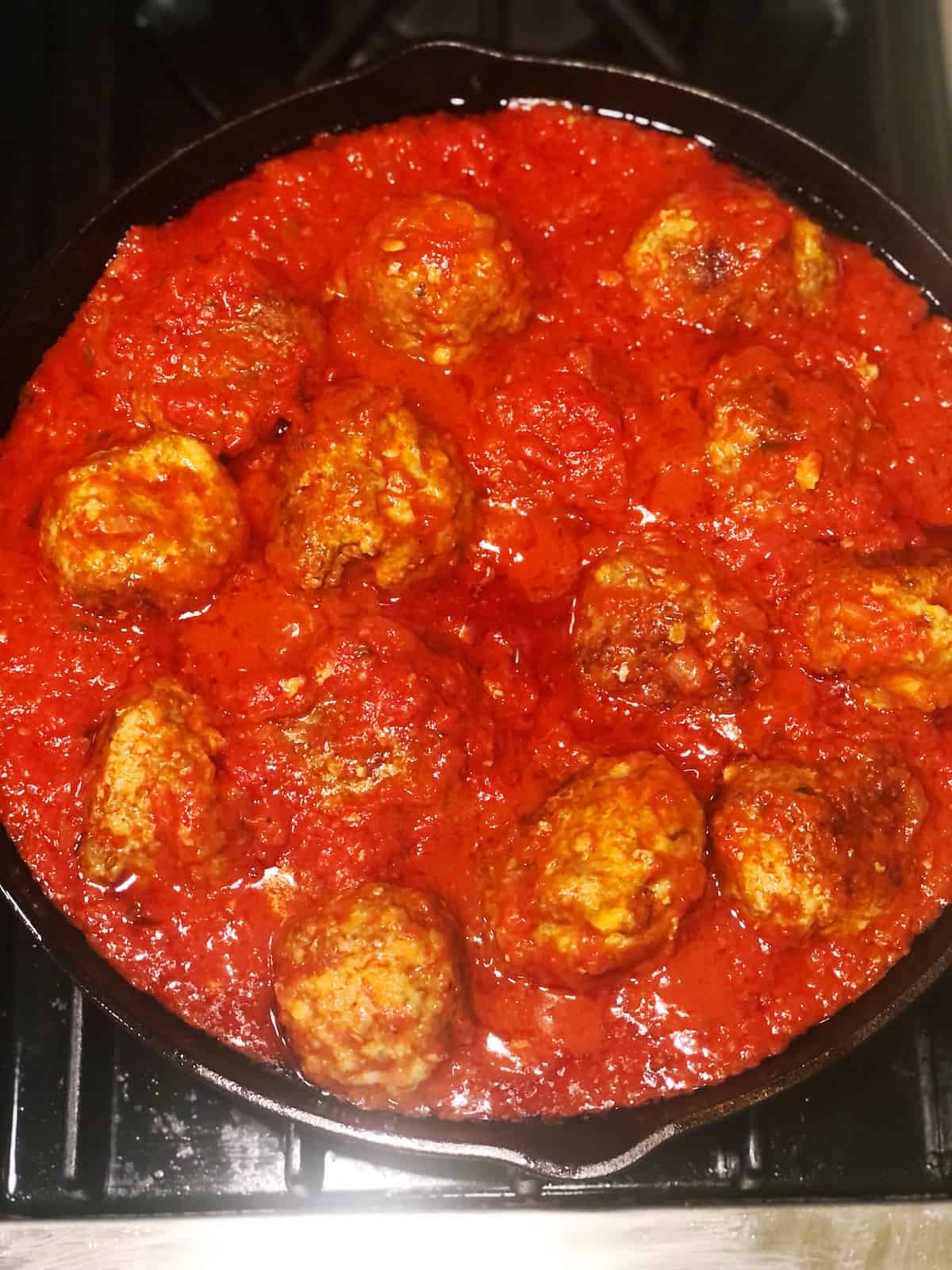 Meatballs in tomato sauce in a skillet.