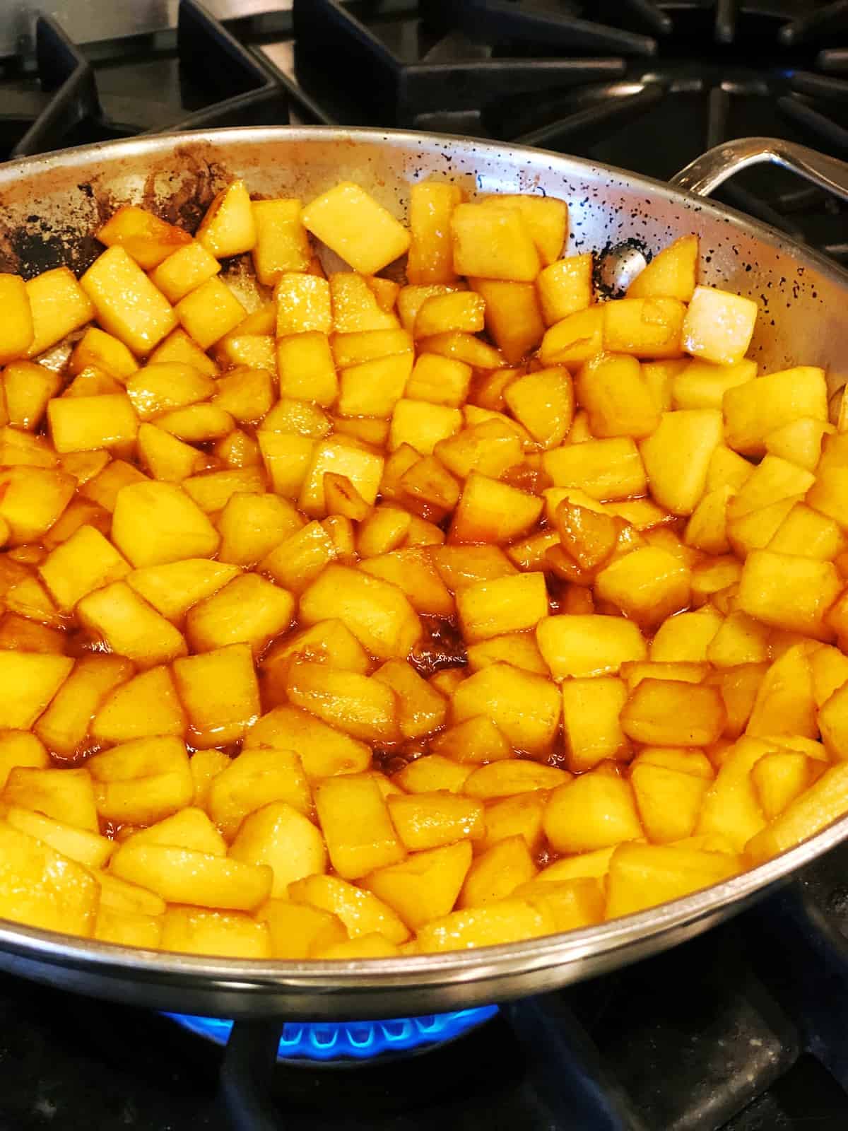 A pan full of cooked food on a stove top.