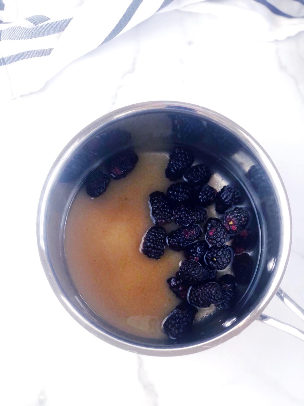 A pot with blackberries in it.