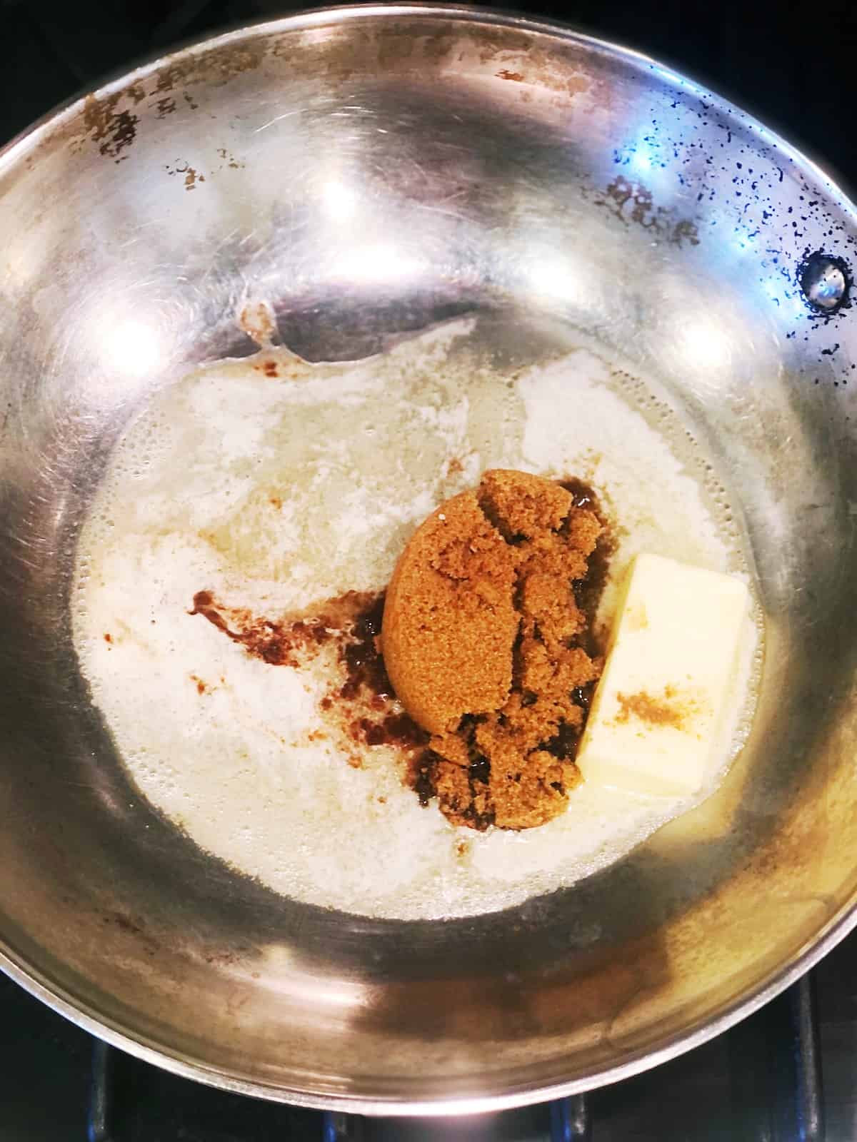 Butter and sugar in a pan on a stove.