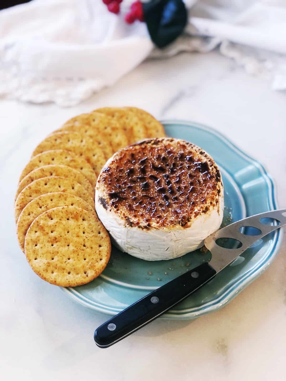 A plate with cheese and crackers on it.