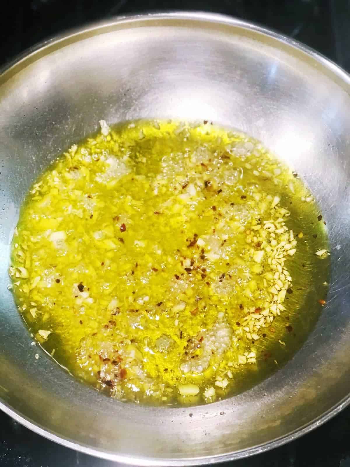 Olive oil in a pan on a stove top.