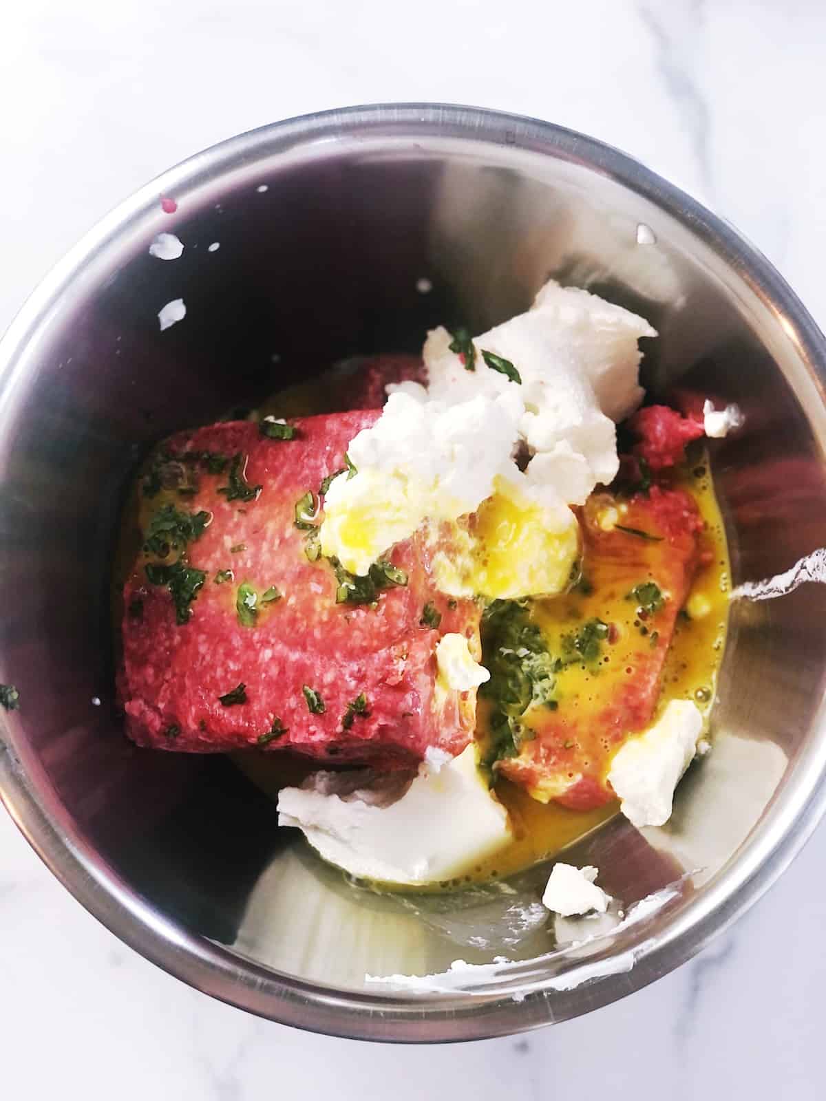 A bowl with meat, and herbs.