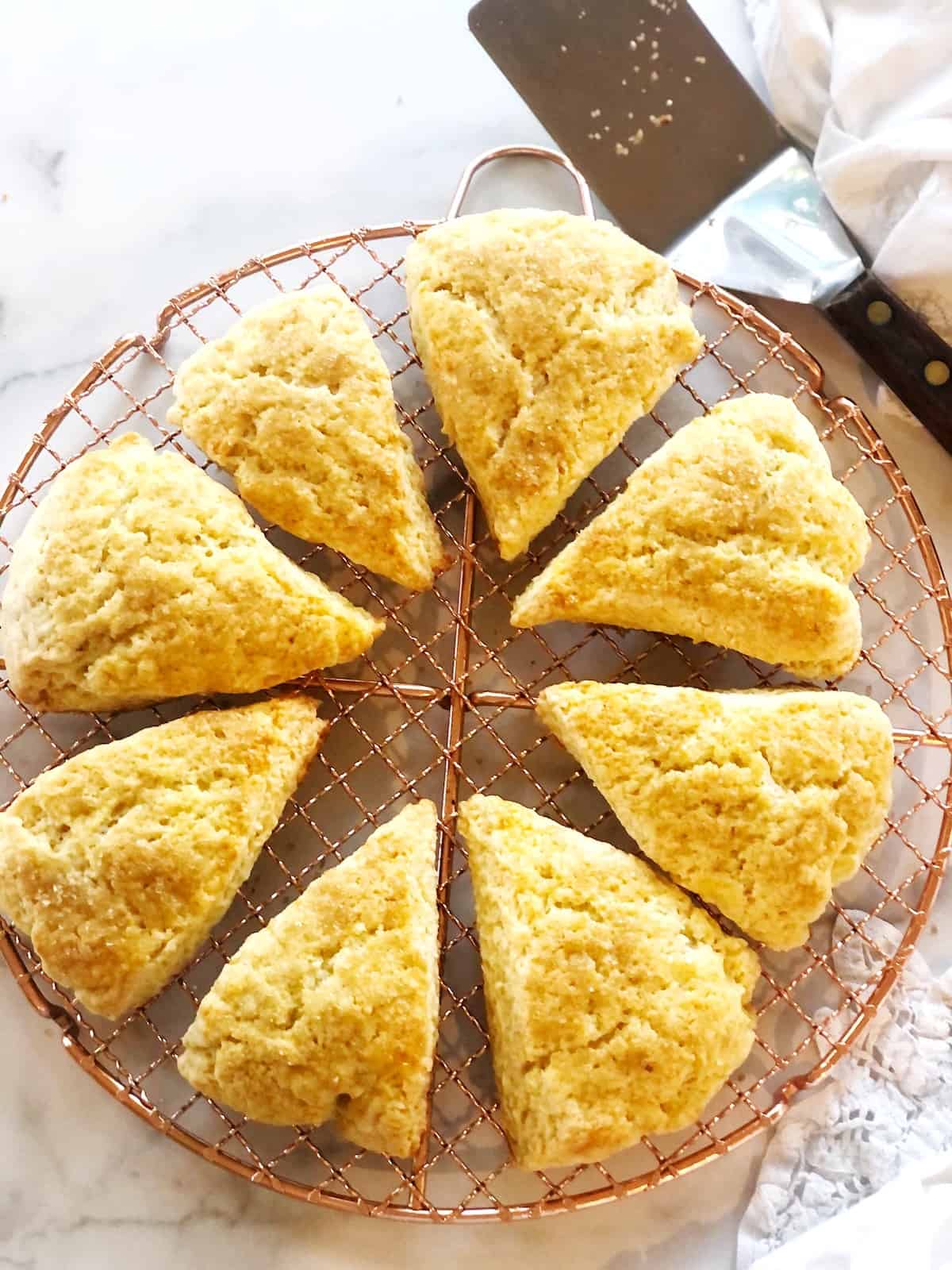 Scones on a cooling rack with a knife.