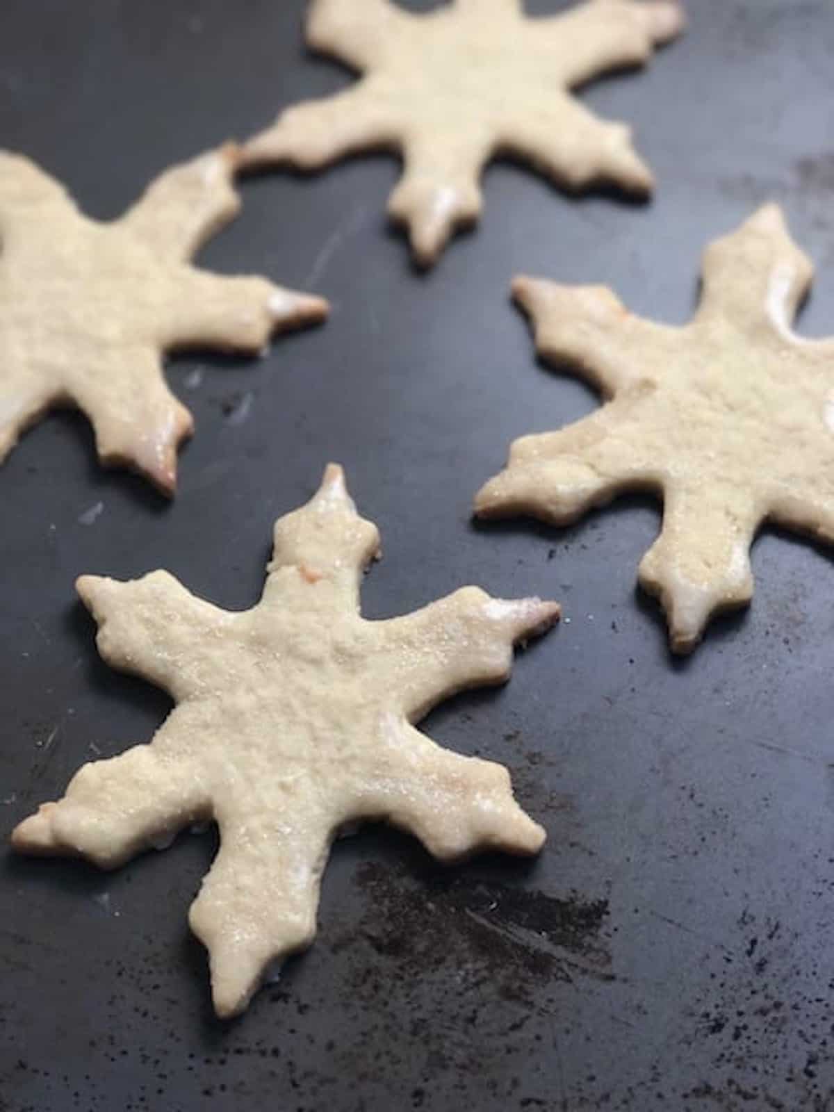 Snowflake cookies on a baking sheet.