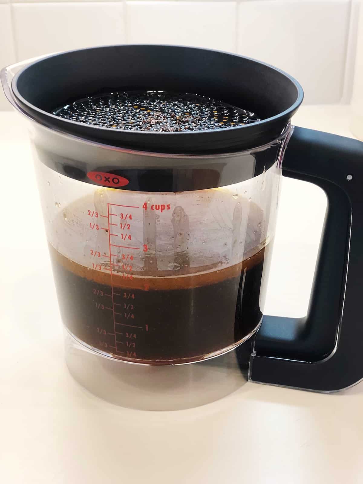 A fat separator with pan drippings in it.