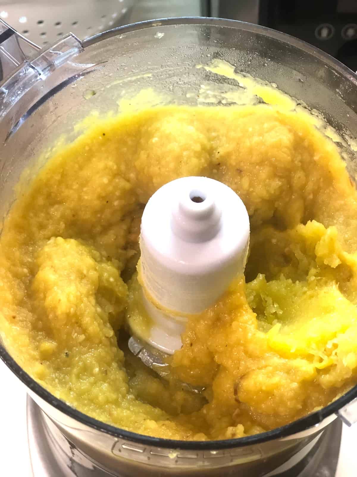 A food processor filled with pureed acorn squash.