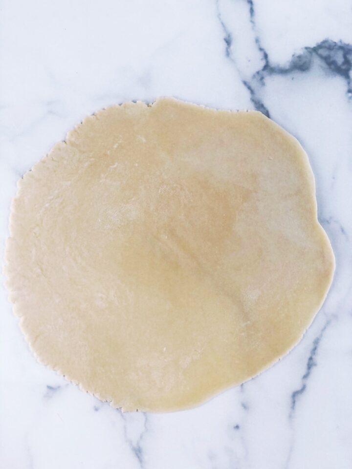 A piece of dough on a marble surface.