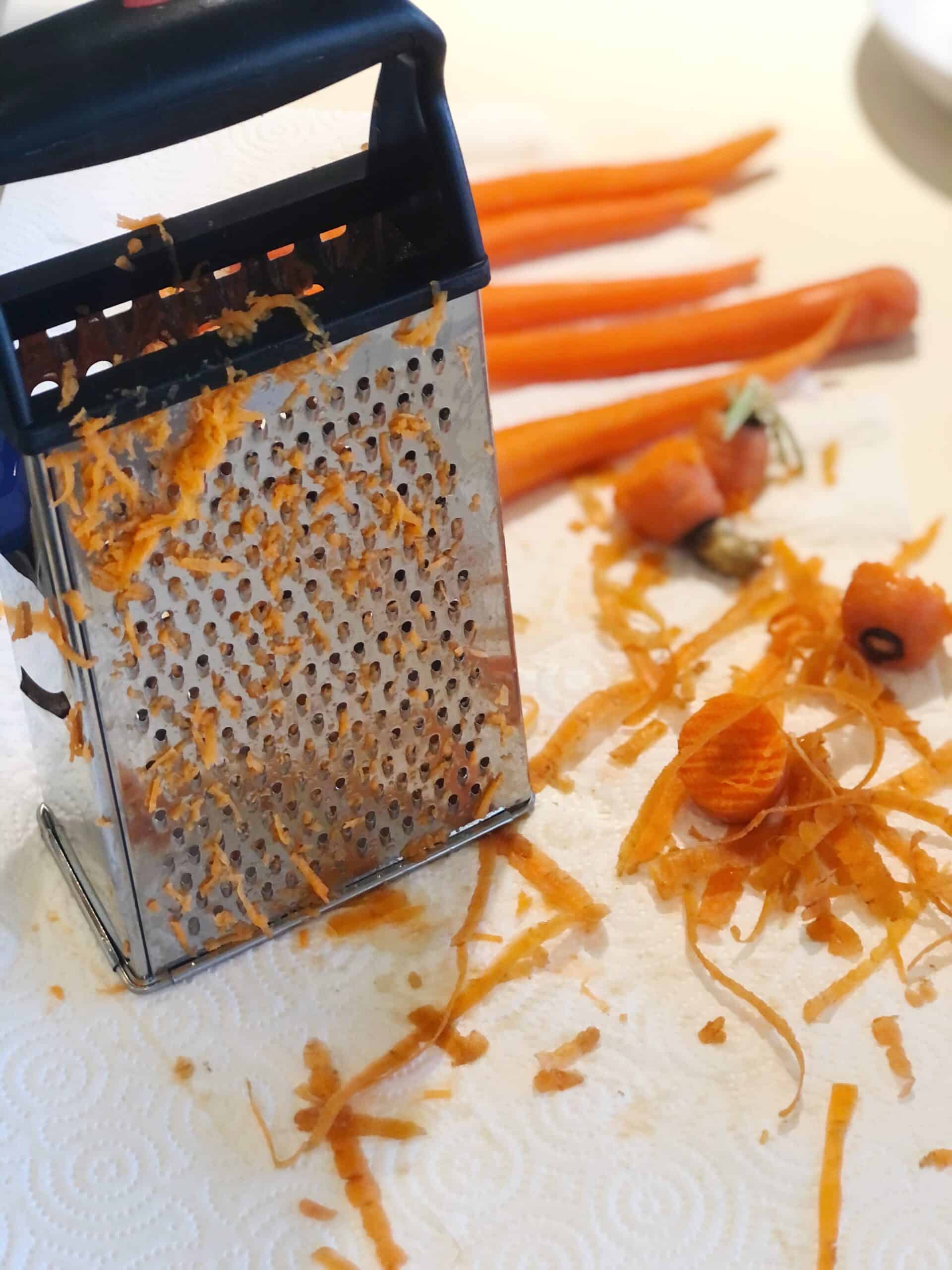 A grater with carrots on it.