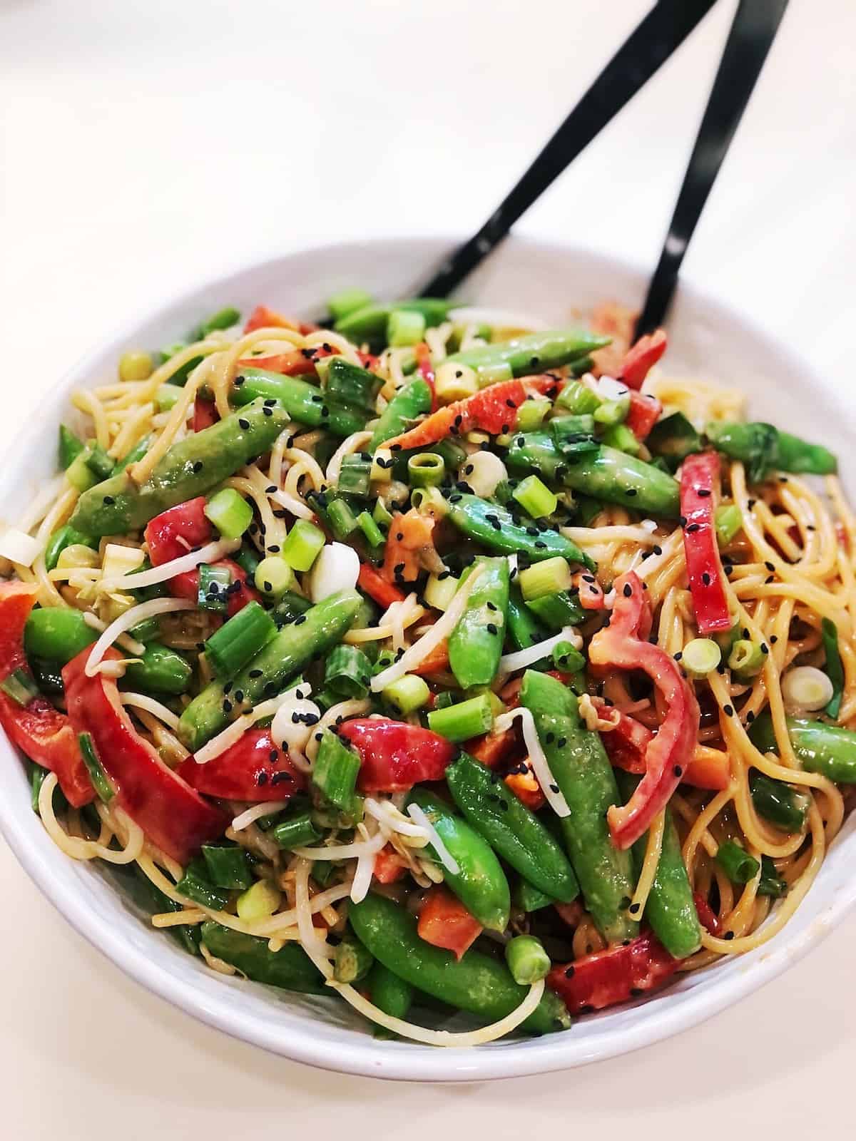 peanut pasta salad tossed together in a large bowl.