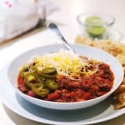smoked brisket chili with toppings in a bowl on the counter.