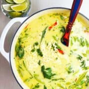 coconut curry soup in a large pot with a spoon.
