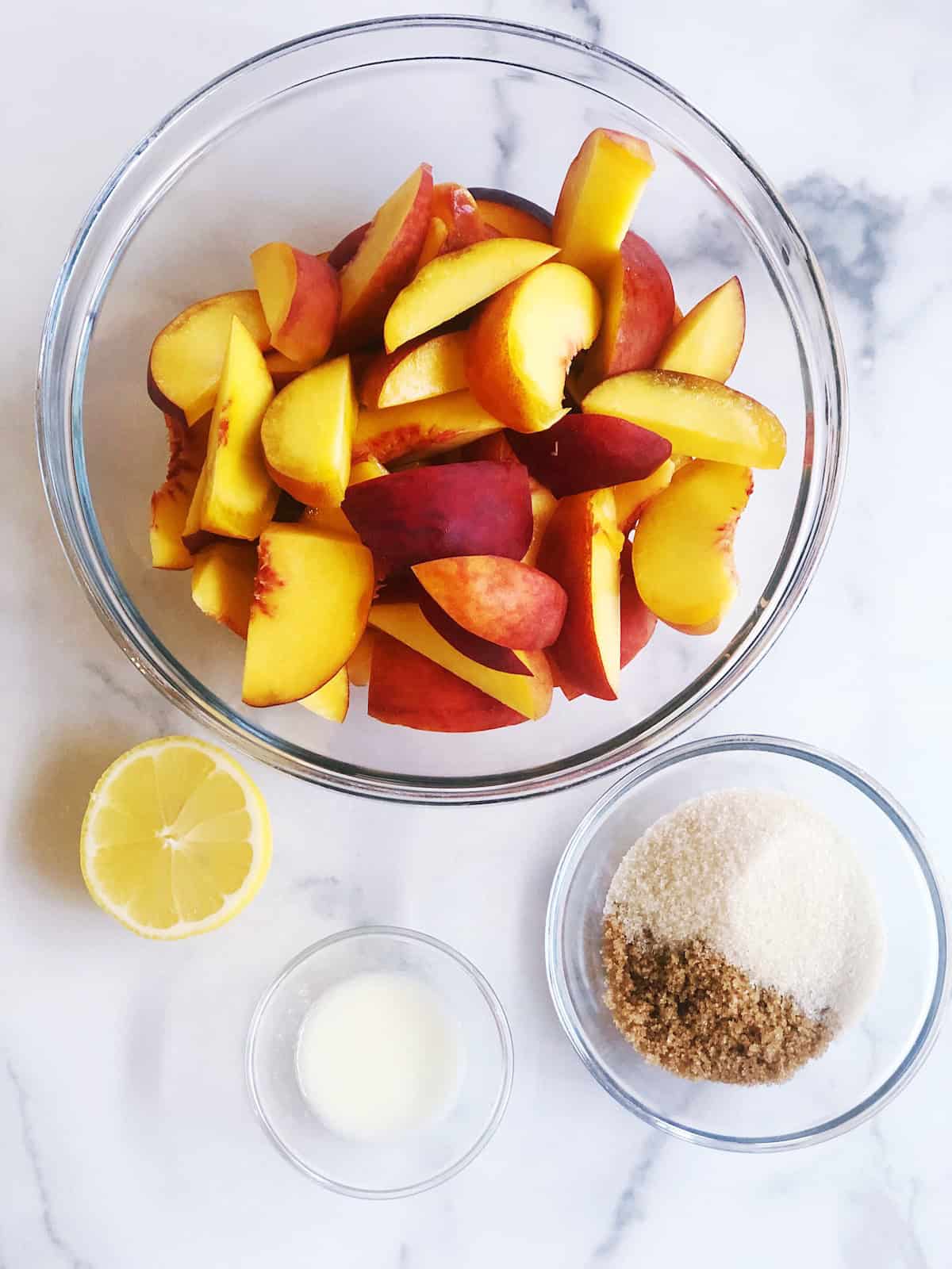 Ingredients for the peach cobbler with pie crust on the counter.