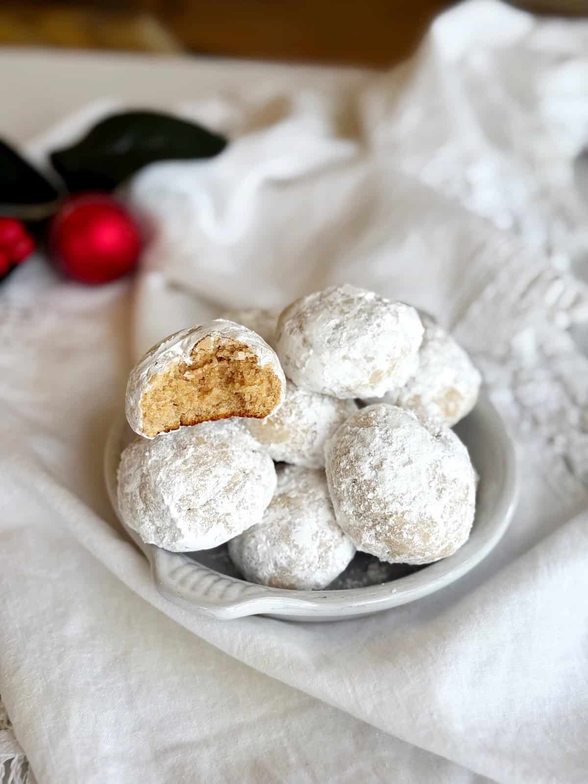 Cinnamon cream cheese snowball cookies on a small plate.