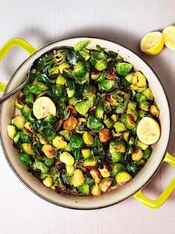 Brussels sprouts cooked up in a pan with lemon.