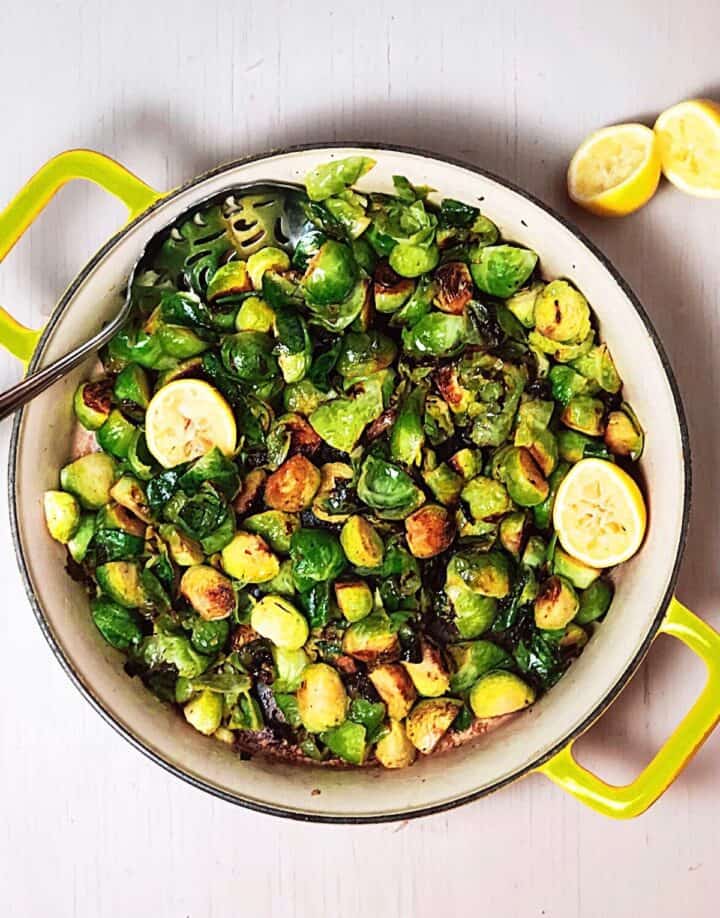 Brussels sprouts cooked up in a pan with lemon.