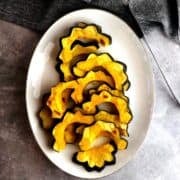 Roasted acorn squash slices on a plate.