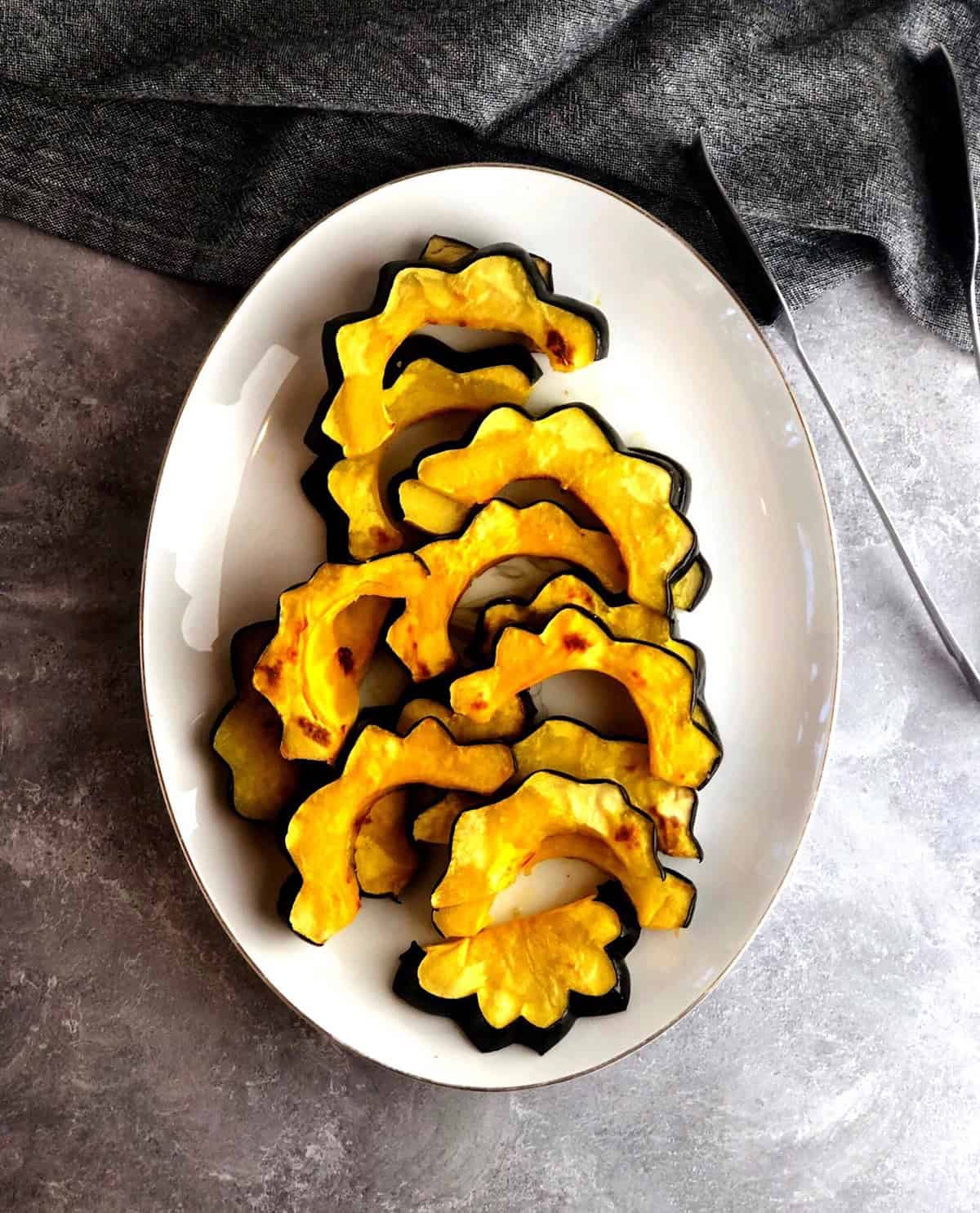 Roasted acorn squash slices on a plate.