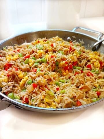 Fried rice with leftover pork in a large pan.